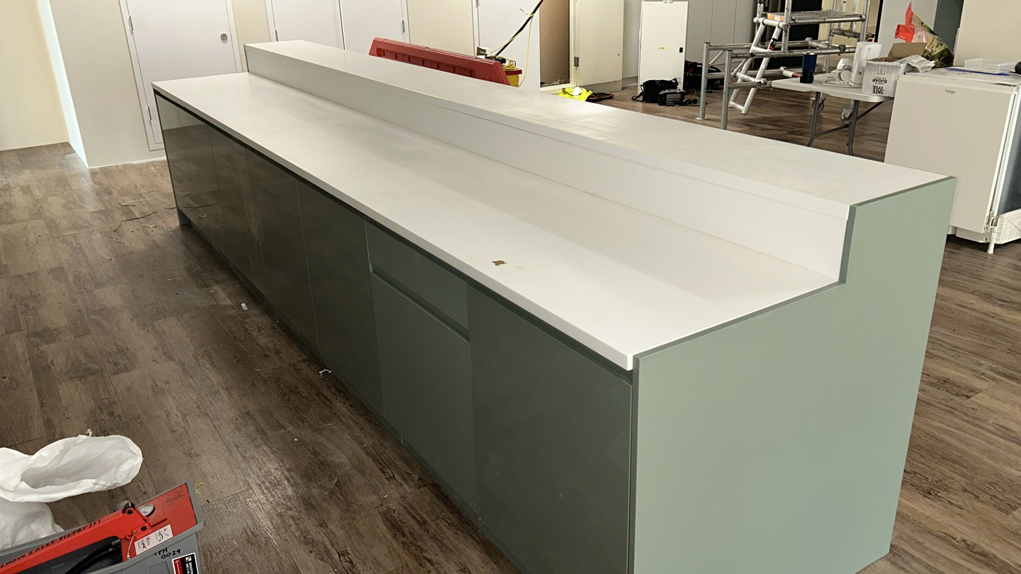 Central breakfast bar island with HiMacs worktop and sage cabinetry